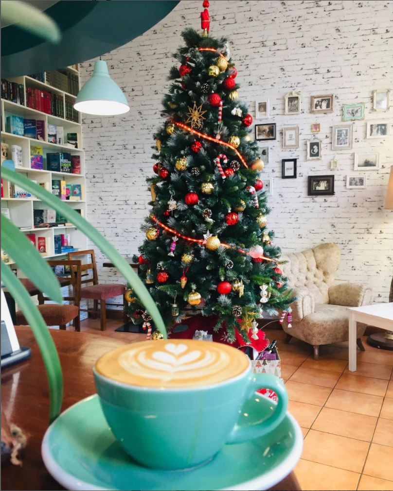 Café Innenansicht mit Kaffeetasse und Weihnachtsbaum